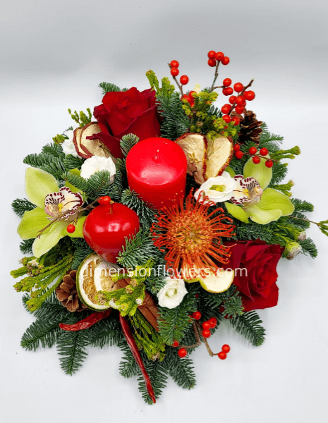 Composizione natalizia con abete, candele, orchidee. rose, bacche e frutta essiccata 